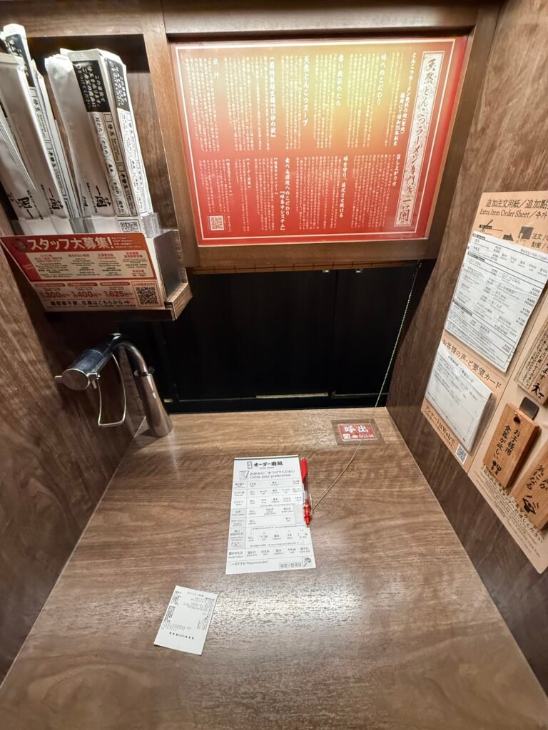 이치란 맛 집중 카운터 주문 용지와 개인 좌석 테이블