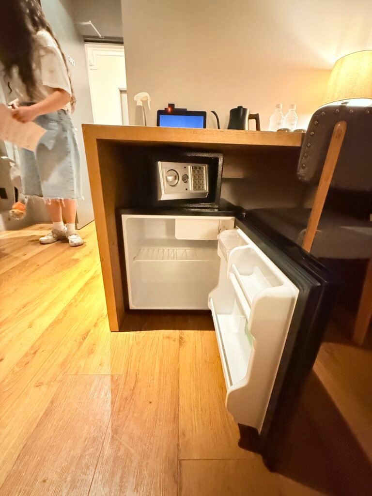 객실 책상 아래 문을 열어 확인한 소형 냉장고와 금고