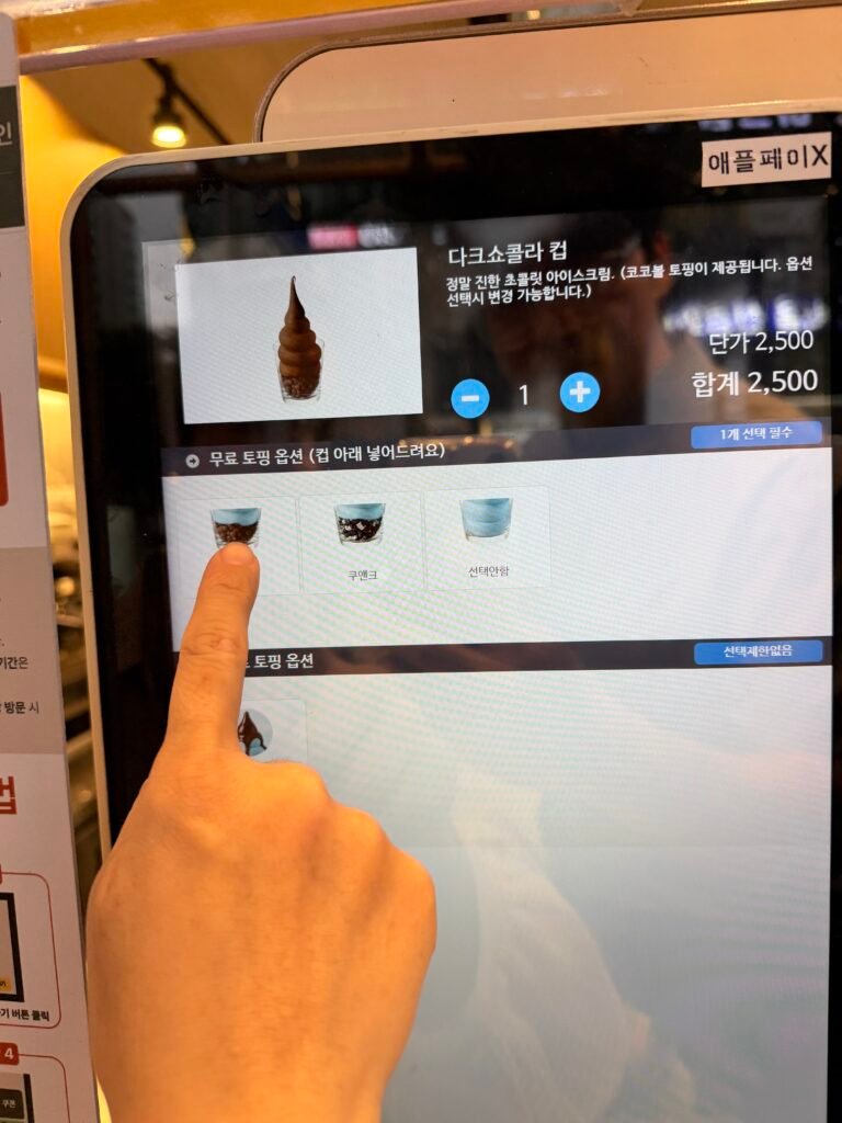 다크쇼콜라컵에 코코볼 무료 토핑을 선택하는 모습