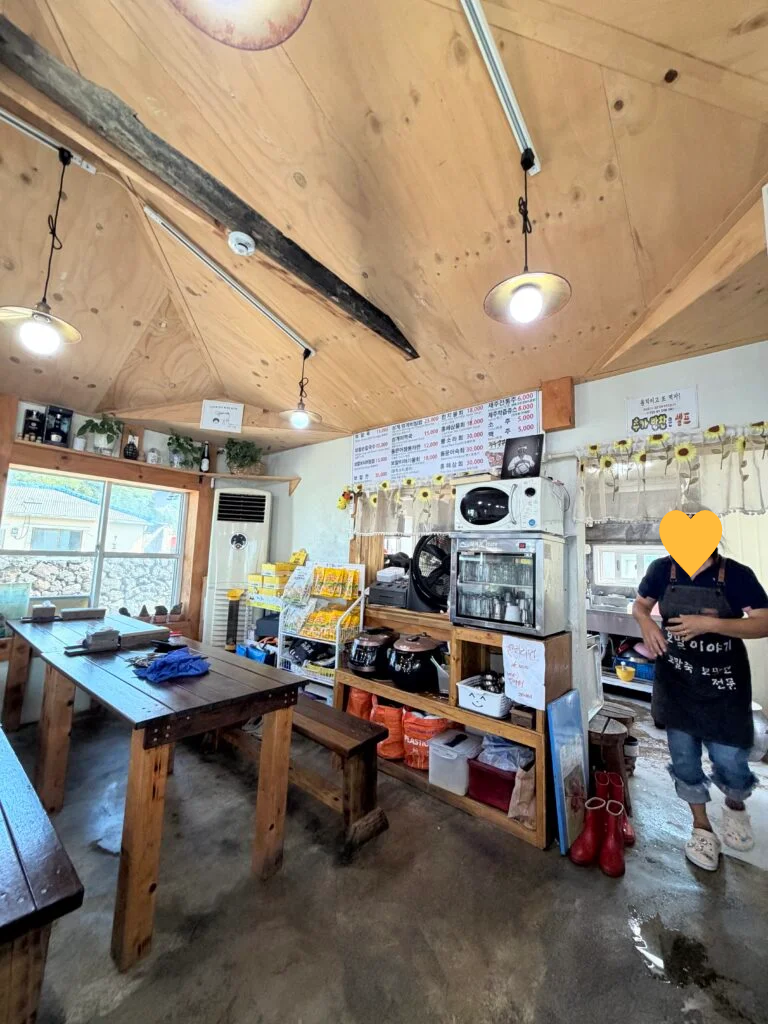 나무 테이블과 메뉴판이 보이는 보말이야기 식당 내부