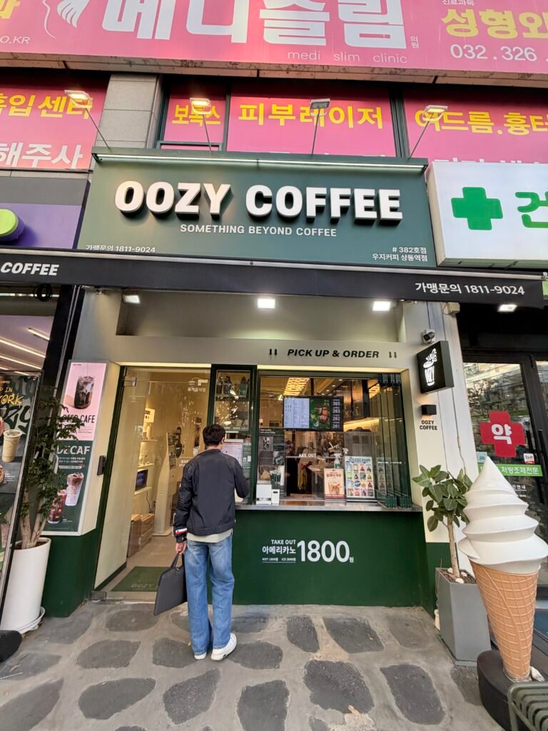 우지커피 상동역점 간판과 매장 출입구 전경